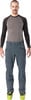 Mann in grauem Langarmshirt und dunkelblauen Skihose mit Skischuhen.