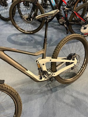 Detail eines Mountainbikes mit Dämpfer und Federung auf blauem Teppich. Detail eines Mountainbikes mit Dämpfer und Federung auf blauem Teppich.