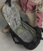Ein offener schwarzer Rucksack mit Innentaschen und einer Person in Skibekleidung.