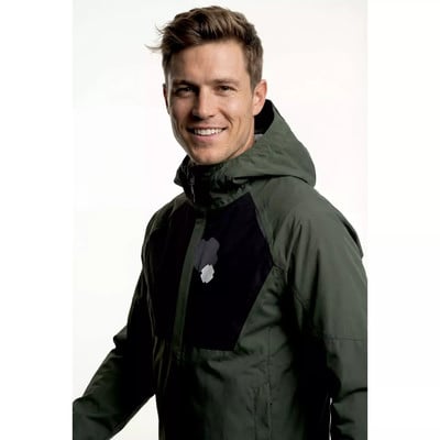 Ein Mann in einer grünen Kapuzenjacke lächelt in die Kamera.