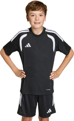 Junge in schwarzem Fußballtrikot und Shorts mit weißen Adidas-Streifen.