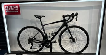 Schwarzes Rennrad mit Logo am Rahmen und zwei Flaschenhaltern.