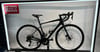 Schwarzes Rennrad mit Logo am Rahmen und zwei Flaschenhaltern.