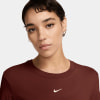 Eine Frau in einem dunkelroten T-Shirt mit Nike-Logo auf der Brust.