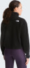 Eine Frau in schwarzer Fleecejacke und lila Leggings im Profil.