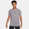 Mann in grauem Nike-T-Shirt mit Nike Court-Logo und Tennisnetz.