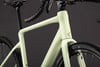 Hellgrünes Gravelbike mit schwarzem Lenker und Sattel, Detailaufnahme.