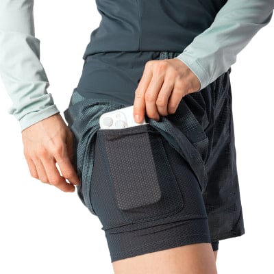 Eine Frau steckt ihr Handy in eine Short mit integrierter Leggings. Eine Frau steckt ihr Handy in eine Short mit integrierter Leggings.