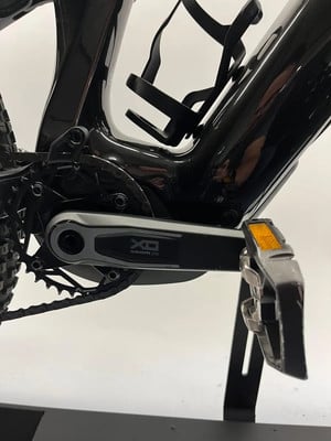 Detail der SRAM XO Kurbel an einem schwarzen Mountainbike-Rahmen. Detail der SRAM XO Kurbel an einem schwarzen Mountainbike-Rahmen.