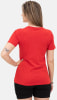 Frau in rotem T-Shirt und schwarzer Hose mit Tattoo auf dem Arm.