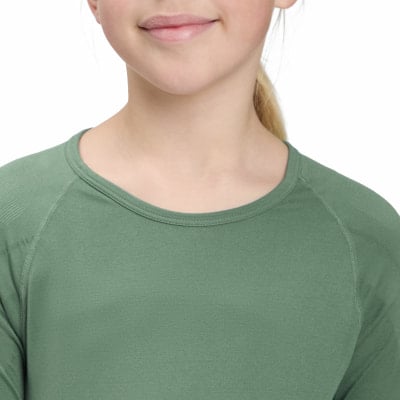 Ein junges Mädchen trägt ein grünes Langarmshirt mit Rundhalsausschnitt. Ein junges Mädchen trägt ein grünes Langarmshirt mit Rundhalsausschnitt.