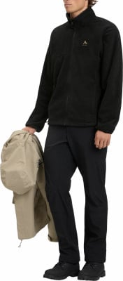 Ein Mann hält einen beigen Mantel in der Hand und trägt eine schwarze Fleecejacke. Ein Mann hält einen beigen Mantel in der Hand und trägt eine schwarze Fleecejacke.
