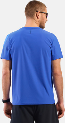 Mann von hinten in blauem Kurzarmshirt und schwarzer Hose.