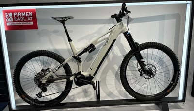 Ein weißes Cube E-Mountainbike mit Federung auf einem Ständer. Ein weißes Cube E-Mountainbike mit Federung auf einem Ständer.