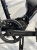 Detail eines Elektrofahrrads mit Kurbeln und Kettenantrieb.
