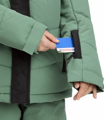 Eine Person in einer grünen Jacke steckt eine Karte in eine Ärmeltasche. Eine Person in einer grünen Jacke steckt eine Karte in eine Ärmeltasche.