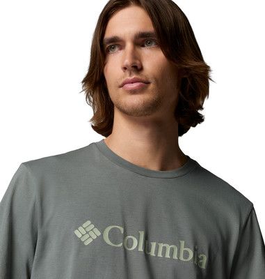 Ein Mann mit langen braunen Haaren trägt ein graues T-Shirt mit Columbia-Logo.