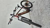 Ein braunes KTM E-Bike mit schwarzen Rädern und Gabel steht auf grauem Untergrund.