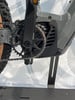 Detail eines E-Bikes mit Kette und Kurbeln am Rahmen.