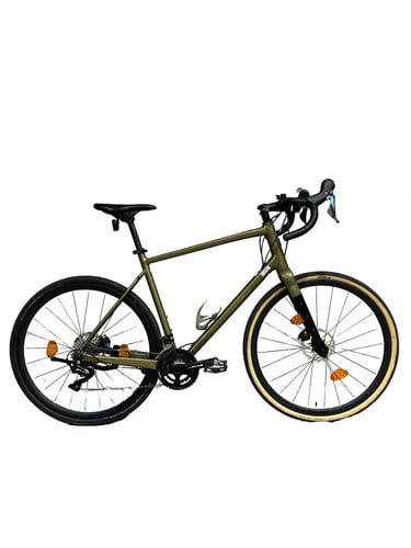 Grünes Gravelbike mit schwarzen Felgen und hellbraunen Reifen.