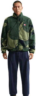 Egy férfi zöld mintás polárdzsekiben és sötétkék nadrágban.