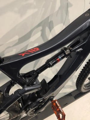 Detail eines Mountainbike-Rahmens mit Dämpfer und orangefarbenem Pedal. Detail eines Mountainbike-Rahmens mit Dämpfer und orangefarbenem Pedal.