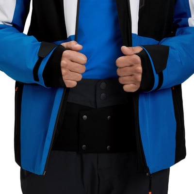 Ein Mann in einer blauen Jacke mit schwarzen Details hält seine Hände vor der Brust. Ein Mann in einer blauen Jacke mit schwarzen Details hält seine Hände vor der Brust.