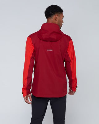 Ein Mann von hinten trägt eine rote Jacke mit Mammut-Logo und schwarze Hose. Ein Mann von hinten trägt eine rote Jacke mit Mammut-Logo und schwarze Hose.