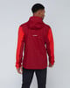 Ein Mann von hinten trägt eine rote Jacke mit Mammut-Logo und schwarze Hose.
