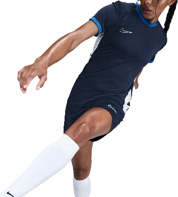 Frau im dunkelblauen Nike Fußballtrikot mit weißen Socken und weißem Streifen. Frau im dunkelblauen Nike Fußballtrikot mit weißen Socken und weißem Streifen.
