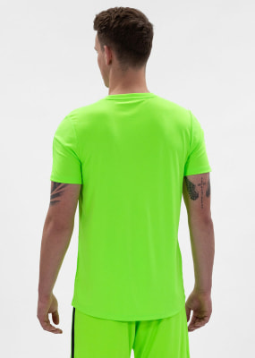 Ein Mann in einem neongrünen T-Shirt und Shorts, mit dem Rücken zum Betrachter. Ein Mann in einem neongrünen T-Shirt und Shorts, mit dem Rücken zum Betrachter.