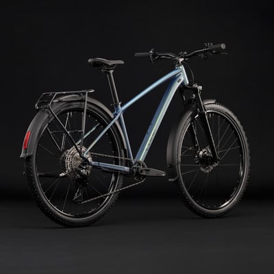 Modernes Mountainbike mit Schutzblechen und Gepäckträger vor schwarzem Hintergrund.