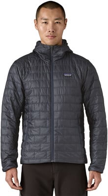 Ein Mann in einer dunklen gesteppten Kapuzenjacke mit Patagonia-Logo.
