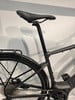 Detail des Sattels und des hinteren Teils eines schwarzen E-Bikes mit Schutzblech und Gepäckträger.