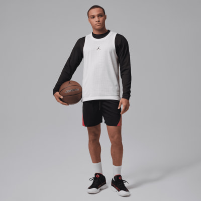 Ein Mann hält einen Basketball und trägt Jordan Sportkleidung. Ein Mann hält einen Basketball und trägt Jordan Sportkleidung.