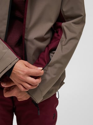 Nahaufnahme einer Jacke mit einer Hand, die einen Ärmelreißverschluss schließt. Nahaufnahme einer Jacke mit einer Hand, die einen Ärmelreißverschluss schließt.