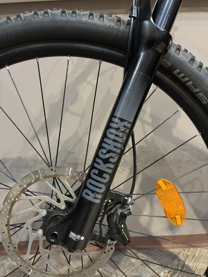 Detail einer Mountainbike-Vorderradgabel mit RockShox-Aufschrift und Scheibenbremse. Detail einer Mountainbike-Vorderradgabel mit RockShox-Aufschrift und Scheibenbremse.