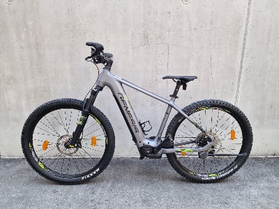Graues E-Bike mit schwarzen Rädern und Genesis-Logo auf dem Rahmen. Graues E-Bike mit schwarzen Rädern und Genesis-Logo auf dem Rahmen.