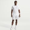 Ein Mann in einem weißen Nike T-Shirt und Shorts mit Logo auf der Brust.