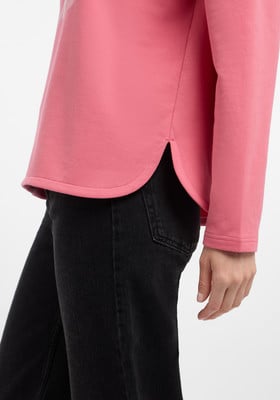 Ein rosafarbener Pullover mit langen Ärmeln und schwarzen Jeans. Ein rosafarbener Pullover mit langen Ärmeln und schwarzen Jeans.