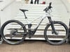 Ein Genesis E-Mountainbike auf einer Treppe mit Dämpfern und Scheibenbremsen.