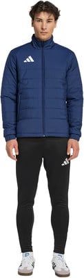 Ein Mann in einer dunkelblauen Steppjacke und schwarzer Trainingshose mit Adidas-Logo. Ein Mann in einer dunkelblauen Steppjacke und schwarzer Trainingshose mit Adidas-Logo.