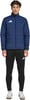 Ein Mann in einer dunkelblauen Steppjacke und schwarzer Trainingshose mit Adidas-Logo.