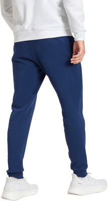 Ein Mann trägt dunkelblaue Jogginghosen und weiße Turnschuhe. Ein Mann trägt dunkelblaue Jogginghosen und weiße Turnschuhe.