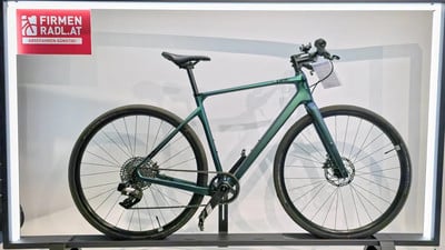 Modernes grünes Gravelbike mit Scheibenbremsen auf einem Ständer. Modernes grünes Gravelbike mit Scheibenbremsen auf einem Ständer.
