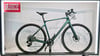Modernes grünes Gravelbike mit Scheibenbremsen auf einem Ständer.