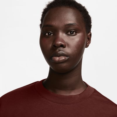 Porträt einer Frau mit kurzen Haaren und dunkler Haut, die ein dunkelrotes T-Shirt trägt. Porträt einer Frau mit kurzen Haaren und dunkler Haut, die ein dunkelrotes T-Shirt trägt.