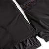 Detail einer schwarzen Jacke mit rosafarbenen Nähten und Druckknopf.