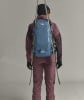 Rückansicht einer Person mit einem Skirucksack und Skiern.