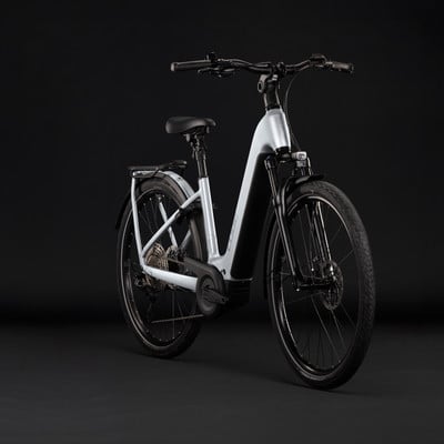 Hellgraues E-Bike mit schwarzen Akzenten vor dunklem Hintergrund. Hellgraues E-Bike mit schwarzen Akzenten vor dunklem Hintergrund.